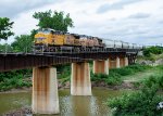 A southbound grain train rolls across Denton Creek 
